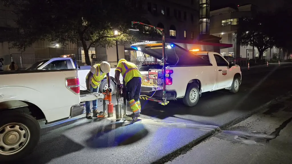 Crew working under lights with traffic control at night